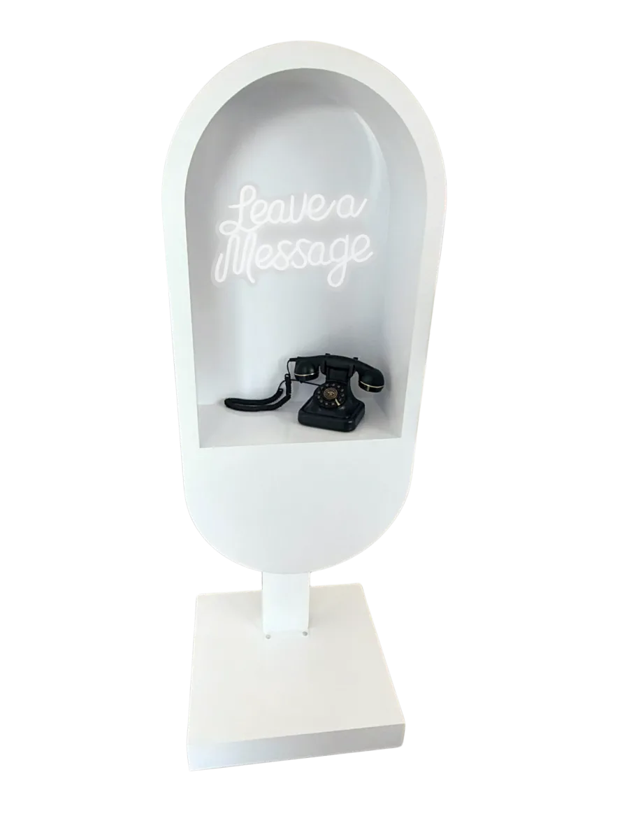 White arch audio guestbook stand with Leave a Message neon sign and vintage black telephone