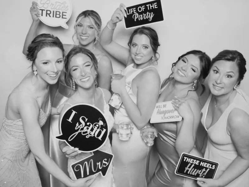Wedding party bridesmaids with black and white photo booth prop signs