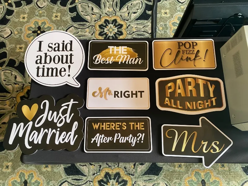 Photo booth prop signs arranged on a table at an event