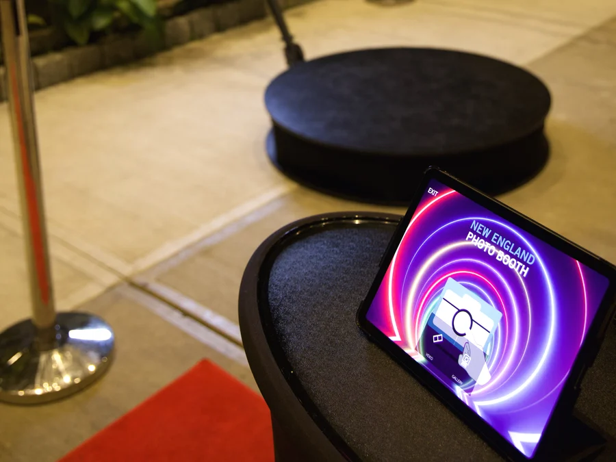 iPad sharing kiosk on its own stand beside the photo booth at an evening event