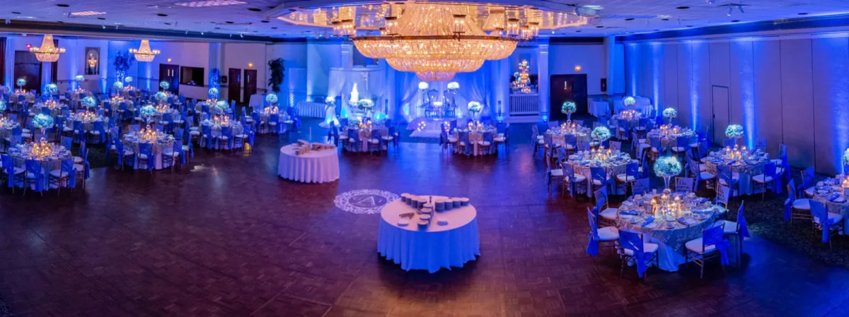 Venue ballroom illuminated with blue and purple LED uplighting at a photo booth event