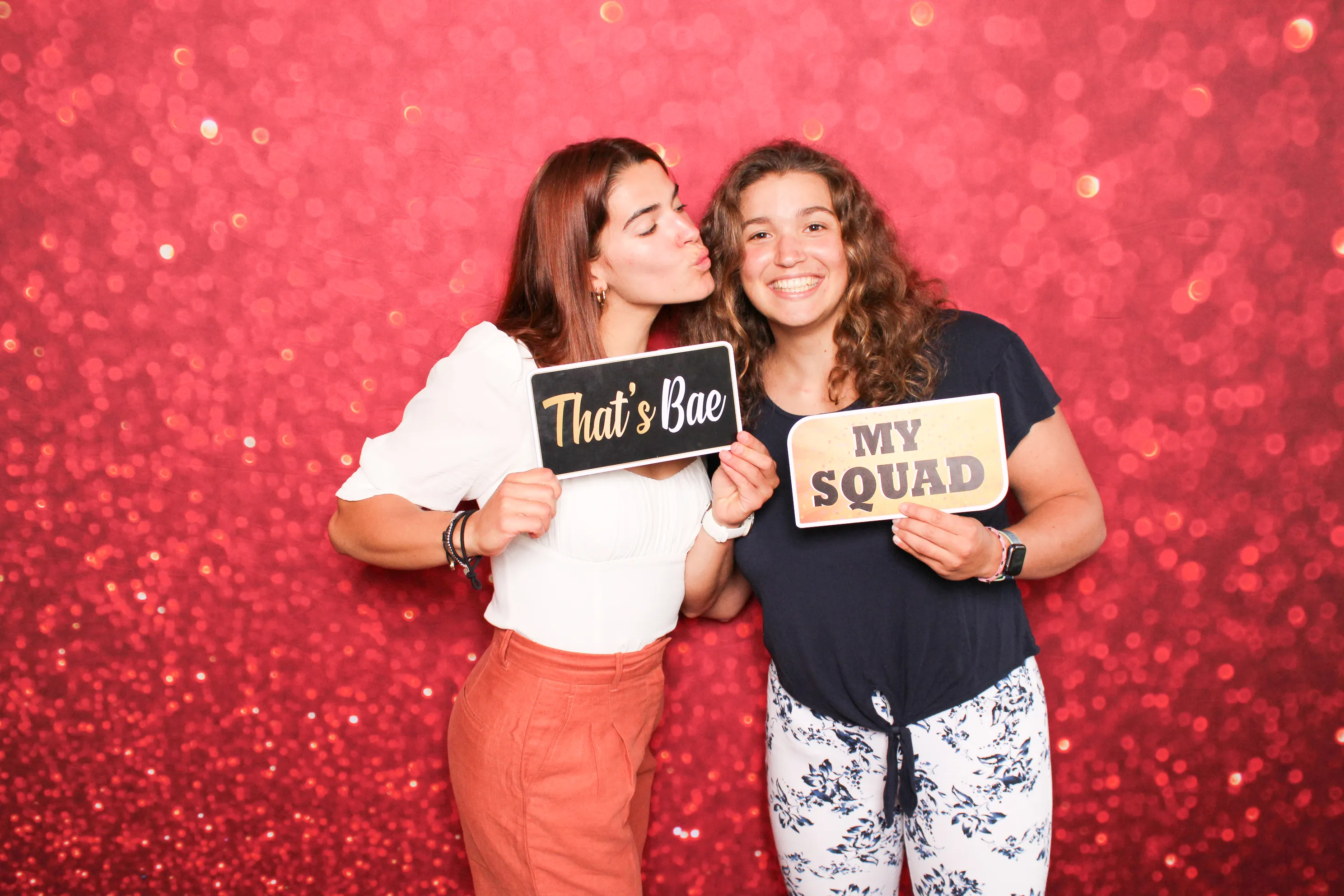 Party guests with silly sign props at photo booth