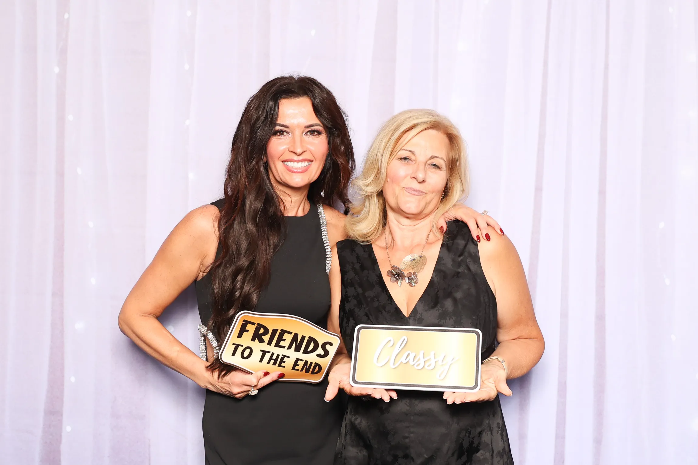 Friends laughing with props at photo booth