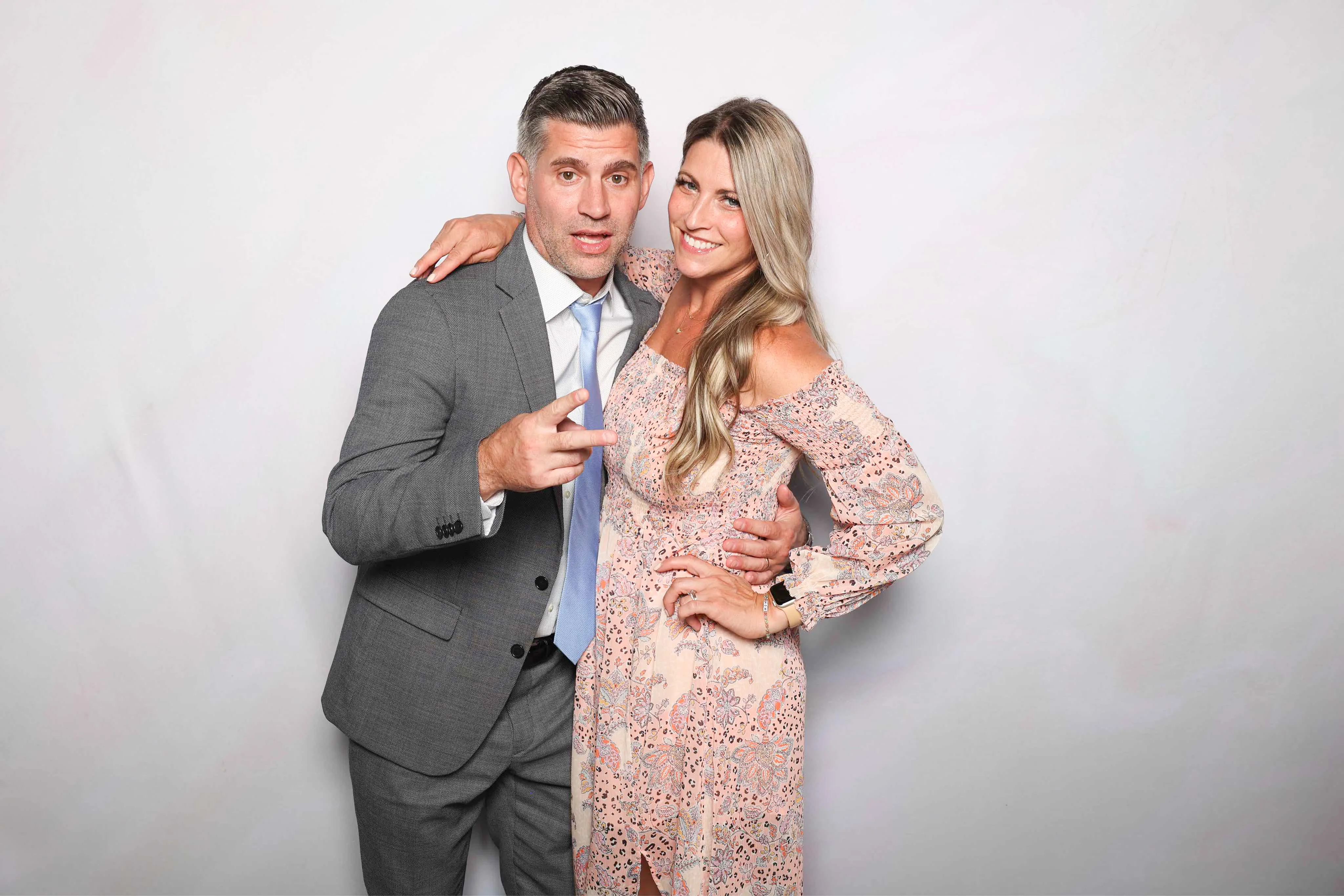 Guests posing with fun signs at party photo booth