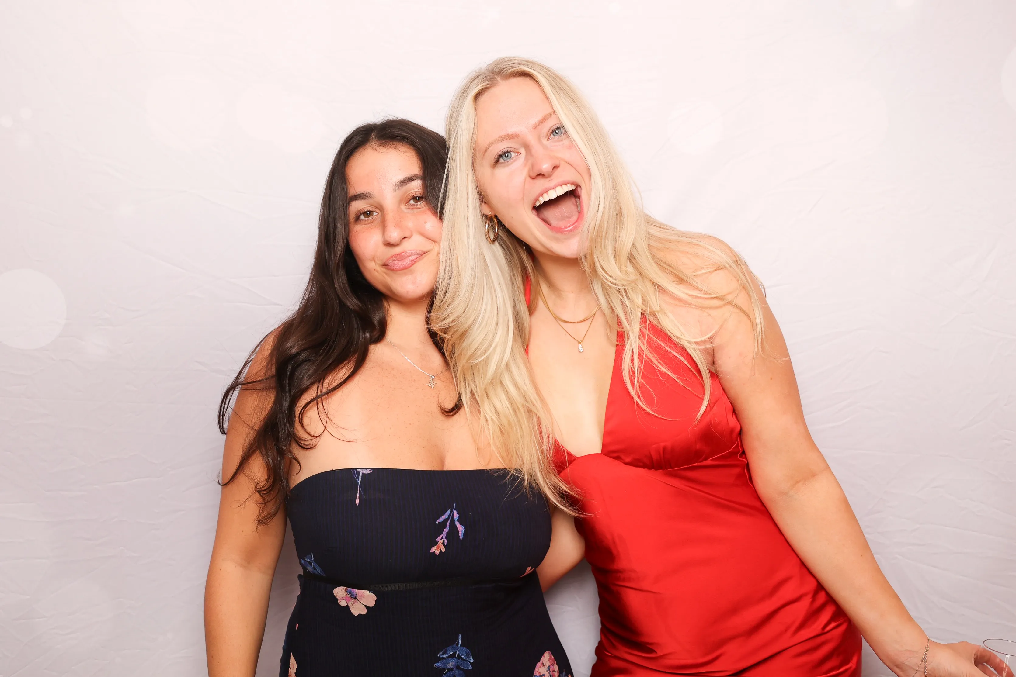 Milestone birthday guests laughing at photo booth