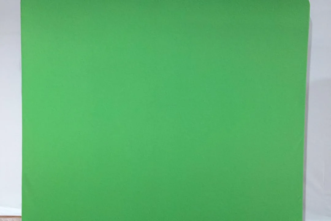Professional green screen tension fabric backdrop on metal frame, wrinkle-free and evenly lit