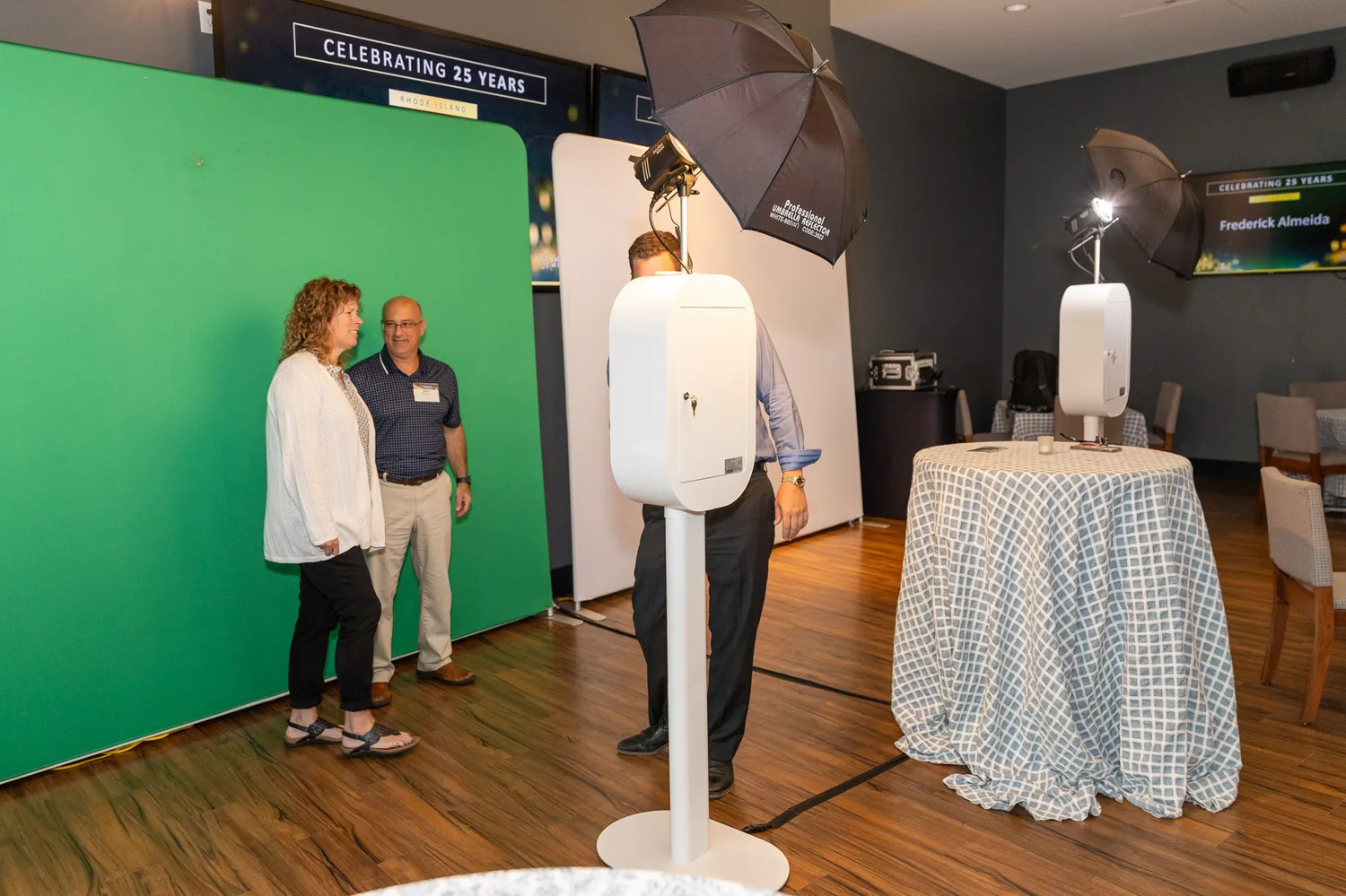 LuxPod photo booth with green screen backdrop and studio lighting set up at a corporate event