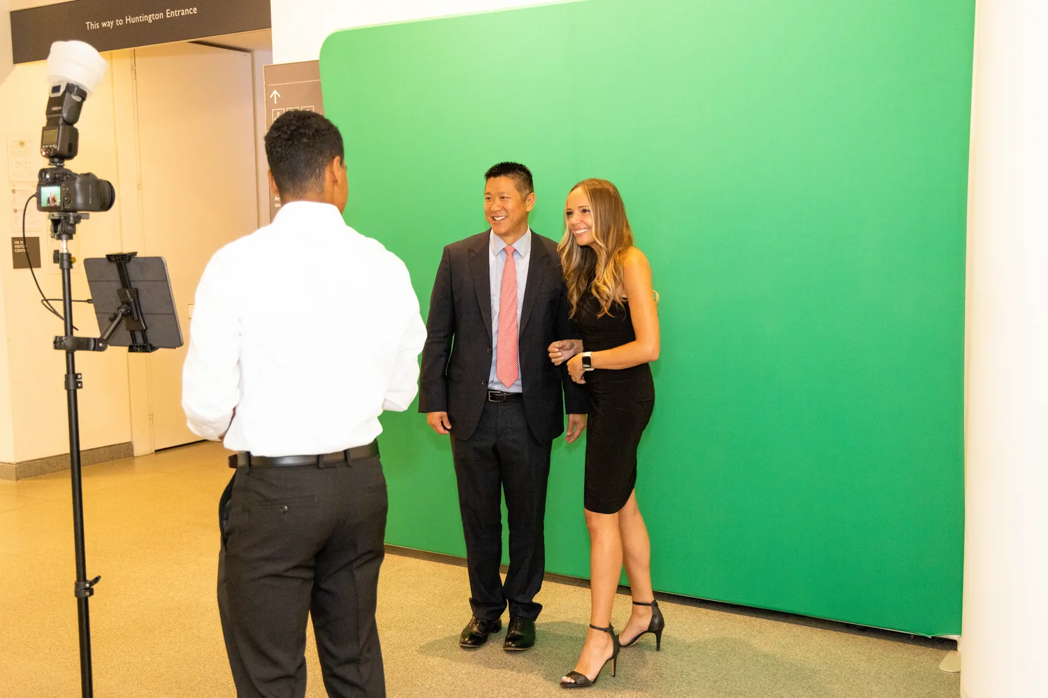 Onsite technician assisting guests posing in front of the green screen photo booth