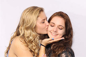 Cheek kisses for the birthday girl in the photo booth