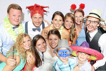 Bride and Groom smile with family and friends in a wedding photo booth 