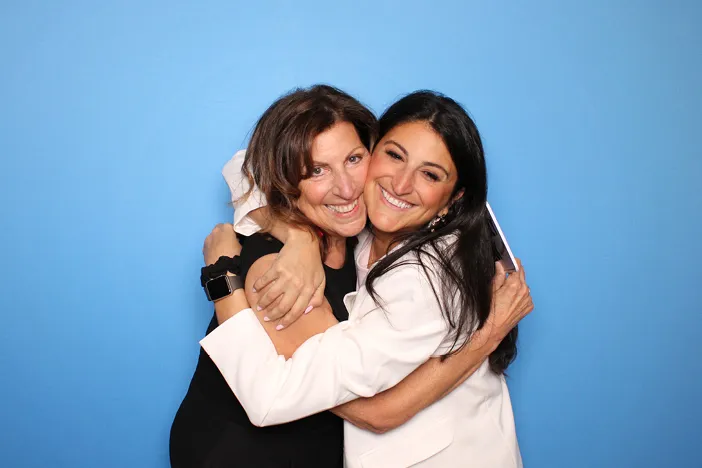 Bride and Groom smile with family and friends in a wedding photo booth 