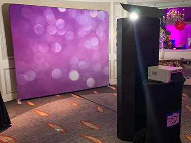 Group of friends laughing while using the Mirror Booth at a birthday celebration