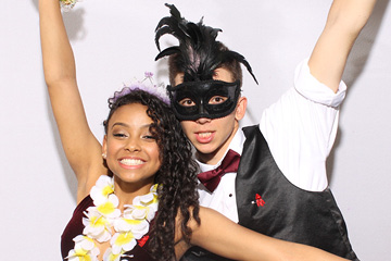 Young couple poses wildly at a photo booth for a college event