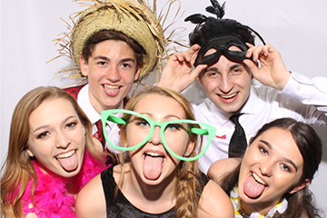 Group of classmates stick out their tongues at a school function photo booth
