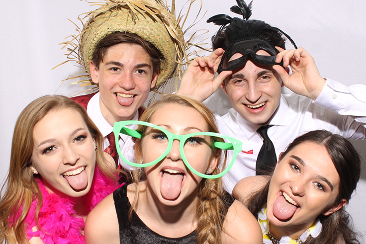 Group of classmates stick out their tongues at a school function photo booth