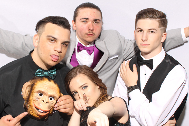 Silly group of students pose for a picture in the booth at their school prom