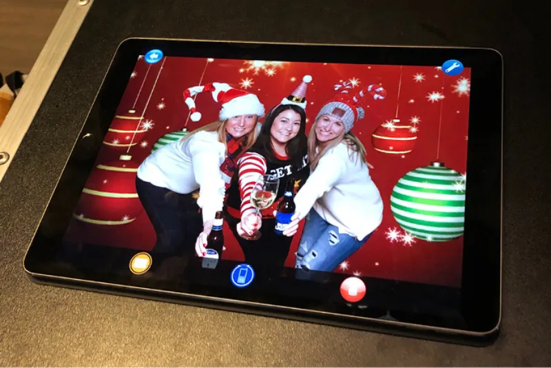 Corporate guests using iPad sharing station to email photo booth pictures