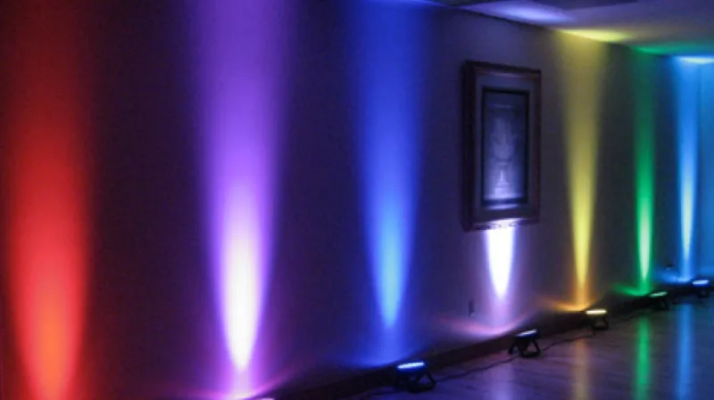 LED uplighting illuminating a wedding reception venue in vibrant colors