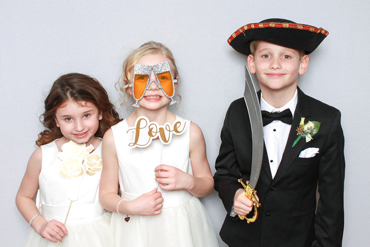 Siblings pose with silly props at a wedding booth rental