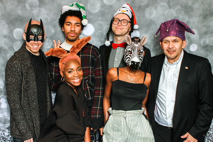Friend group poses with animal masks and other silly props at the fotobooth